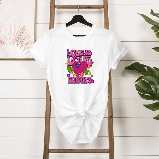 White Love is Love Always t-shirt with colorful retro text and heart design hanging on wooden ladder