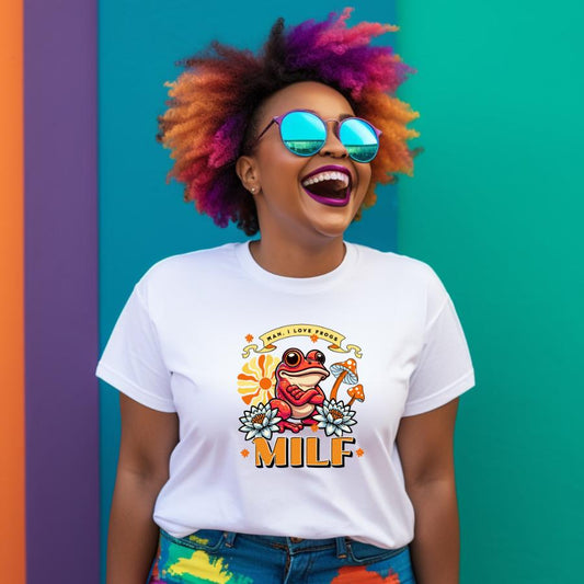 Woman wearing a white Man I Love Frogs T-shirt with colorful frog graphic and text MILF, smiling against a vibrant teal and purple background
