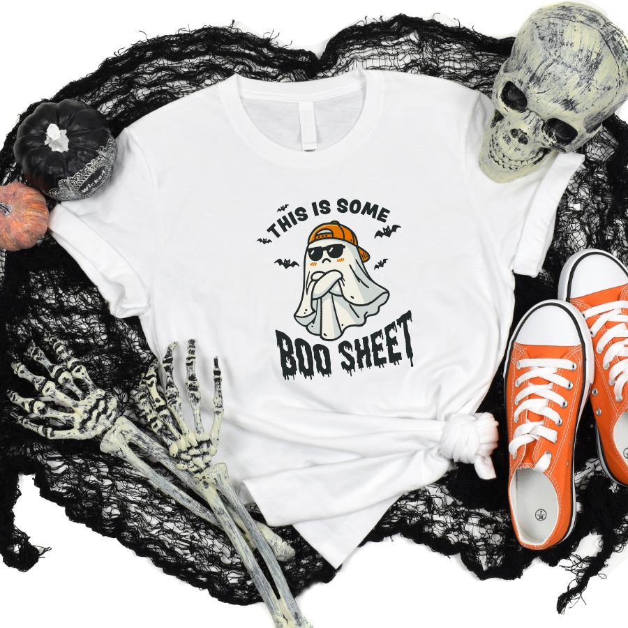 White This Is Some Boo Sheet T-Shirt with ghost pun design, surrounded by Halloween decorations and orange sneakers